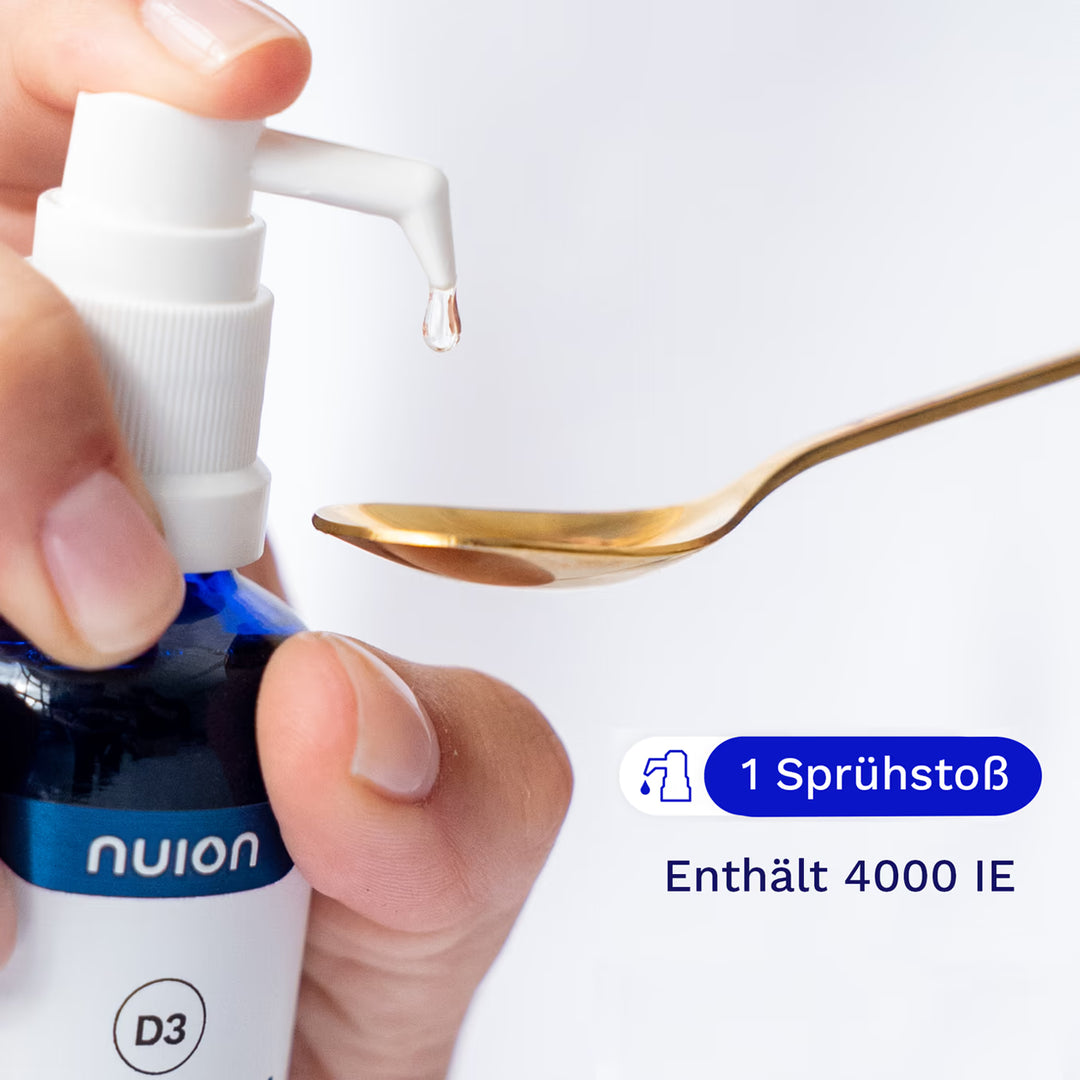Eine Hand hält eine Pipette des blauen Fläschchens von nuion, aus dem ein Tropfen Flüssigkeit auf einen goldenen Löffel fällt. Das Produkt enthält 4000 IE Vitamin D3K2MK7 und wird von der Firma Puromedica angeboten.