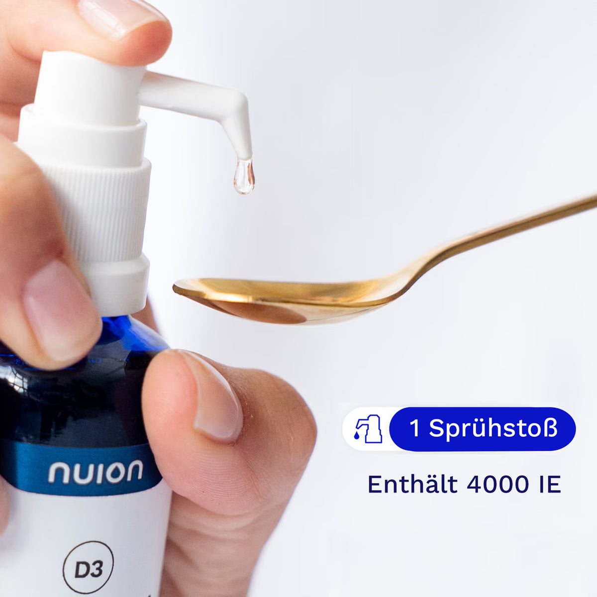 Eine Hand hält eine Pipette des blauen Fläschchens von nuion, aus dem ein Tropfen Flüssigkeit auf einen goldenen Löffel fällt. Das Produkt enthält 4000 IE Vitamin D3K2MK7 und wird von der Firma Puromedica angeboten.
