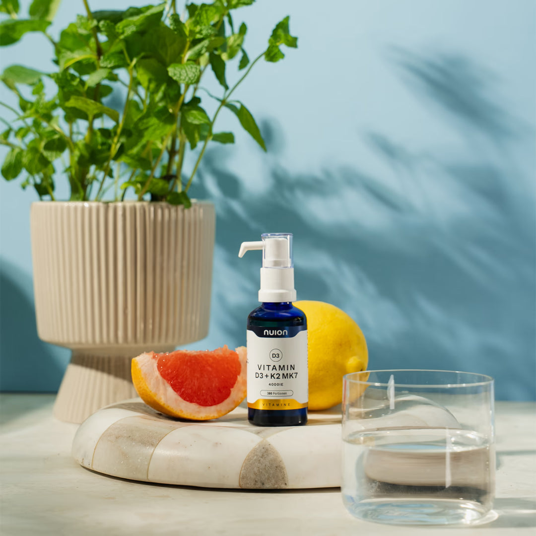 Auf dem Bild ist eine Flasche mit dem Produkt „Vitamin D3K2MK7“ von nuion zu sehen, die auf einem hellen Holztisch steht.