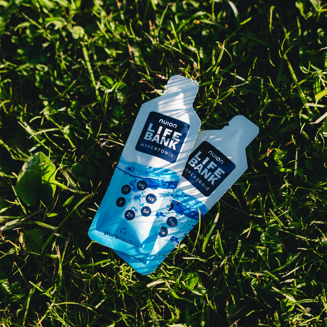 Zwei Verpackungen von Life Bank nuion - Hypertonisch liegen auf grünem Gras. Die Verpackungen sind hellblau und zeigen das Logo von Puromedica sowie die wichtigsten Inhaltsstoffe in klarer Schrift, was auf die Elektrolytformel hinweist.