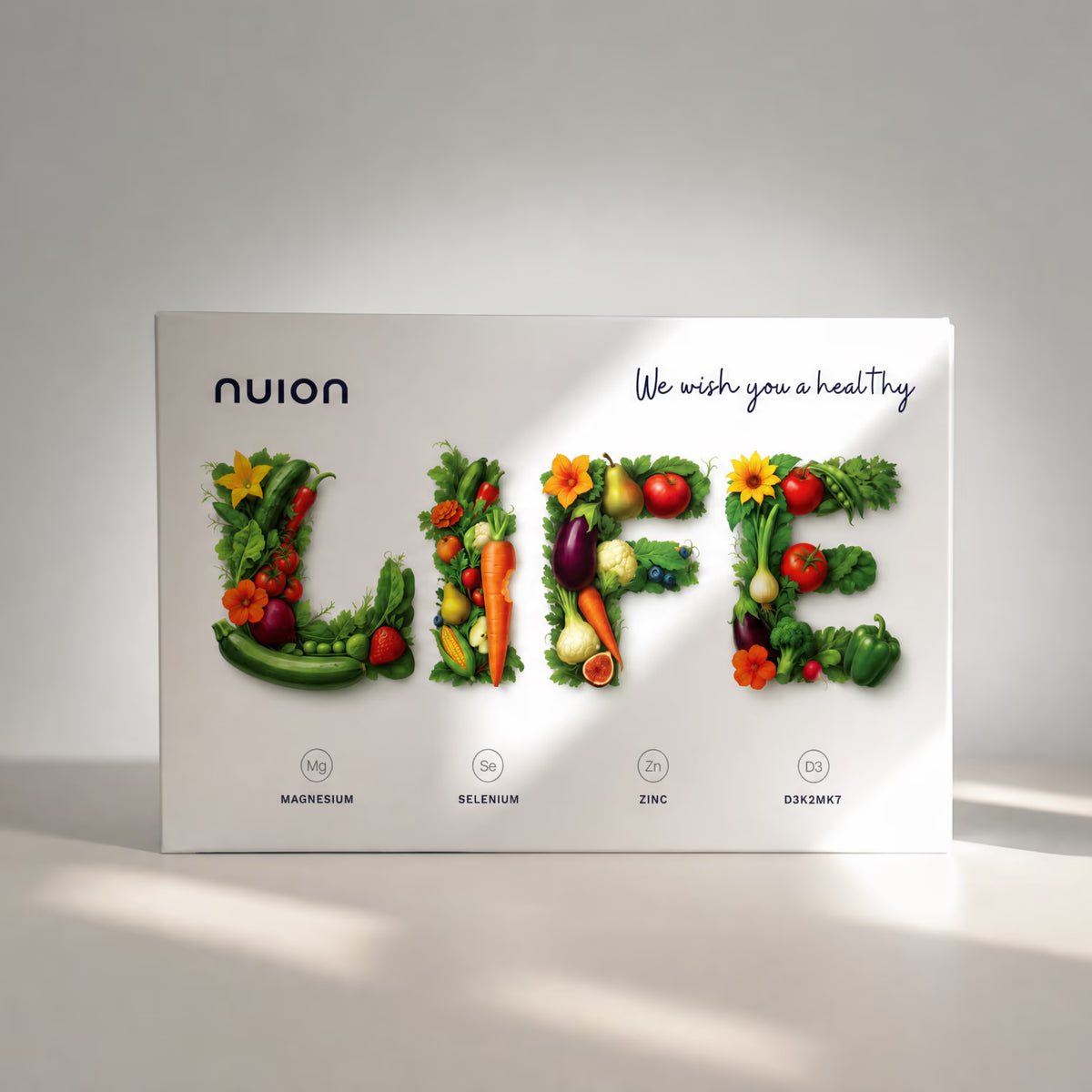 Die Verpackung von Puromedica zeigt das Wort LIFE, das aus verschiedenen frischen Lebensmitteln wie Gemüse und Obst gestaltet ist. Darunter sind die Nährstoffe Magnesium, Selenium, Zink und D3/K2 aufgelistet, die zur Gesundheit beitragen.