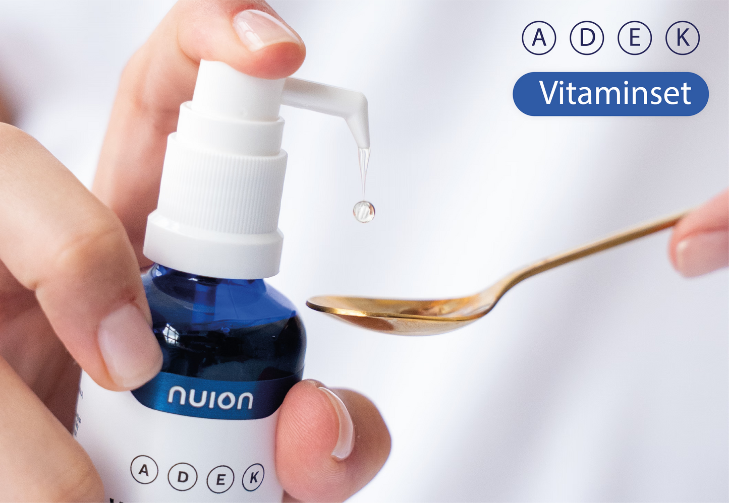 Eine Hand hält eine Flasche mit dem Vitamin ADEK von Puromedica, während die andere Hand einen kleinen Löffel hält, auf dem sich ein Tropfen des Vitamins befindet.